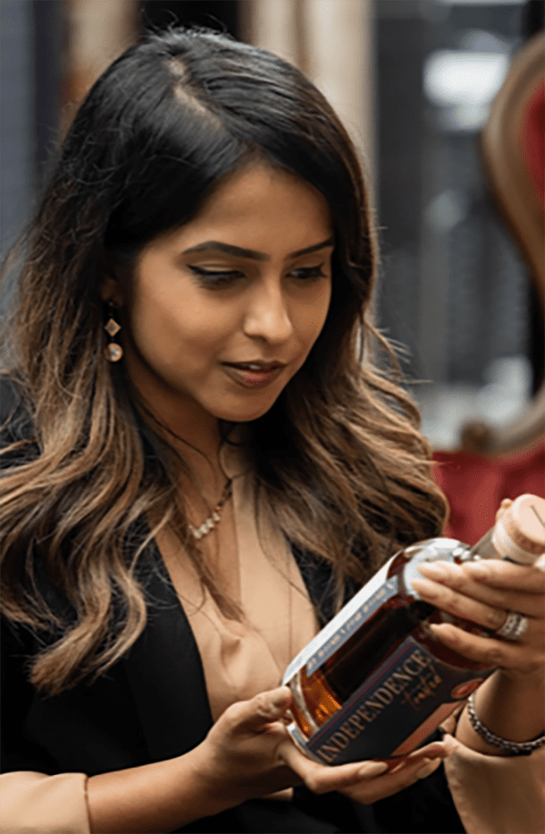 A woman looking at her phone while holding it.