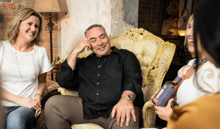 A man sitting on top of a chair next to another person.